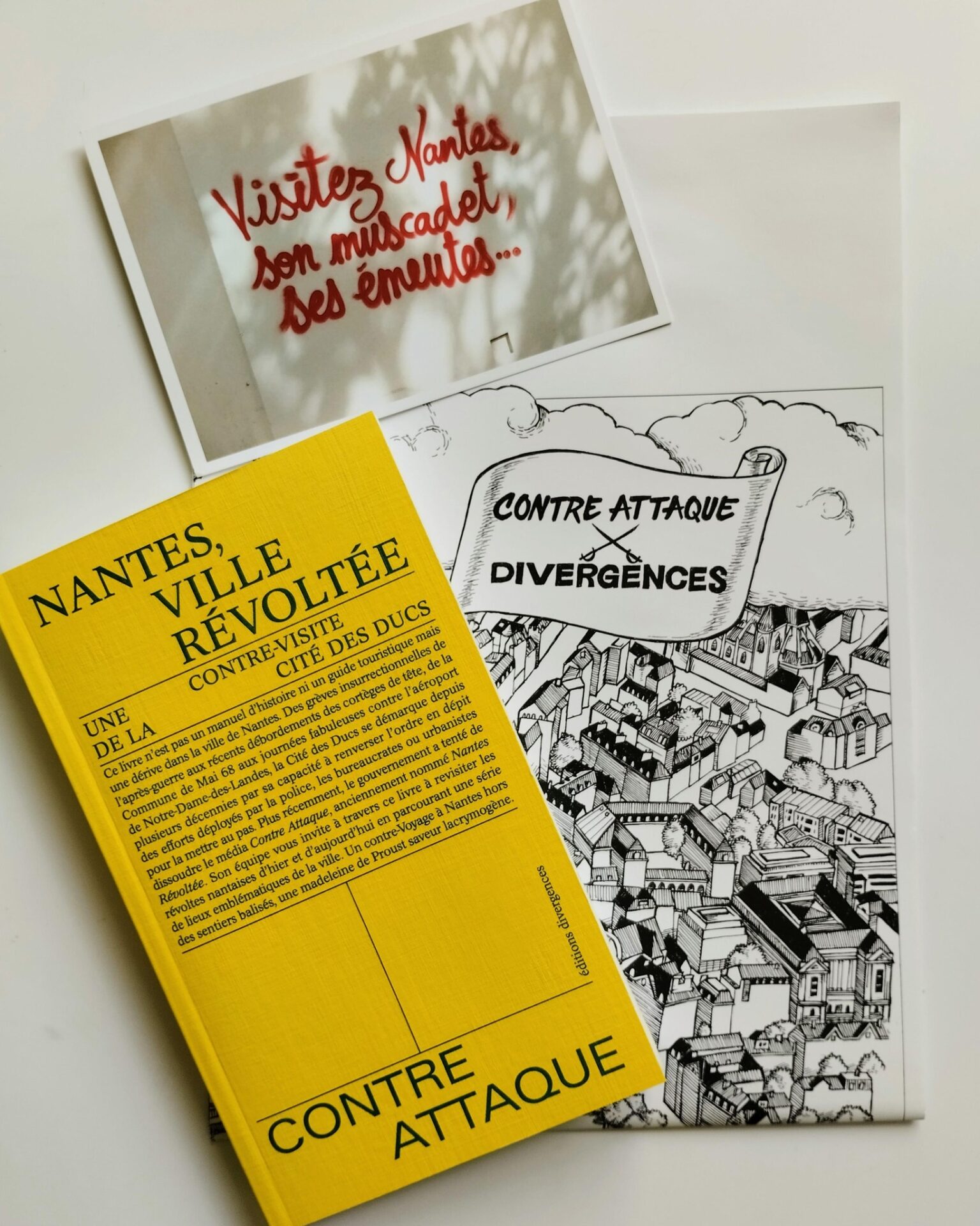 Le livre "Nantes, ville révoltée" accompagné de sa carte grand format et d'une carte postale.